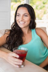 Wall Mural - Pretty brunette sitting on the armchair