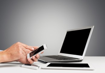 Poster - Laptop. Man hand working with smartphone with computer