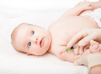 Wall Mural - Pediatrician giving baby girl intramuscular injection in arm