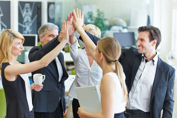 Wall Mural - Business Team macht High Five im Büro