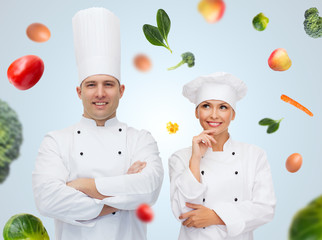 Poster - happy chef couple or cooks over food background