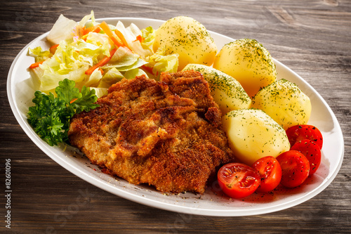 Fototapeta na wymiar Fried pork chop, boiled potatoes and vegetable salad 