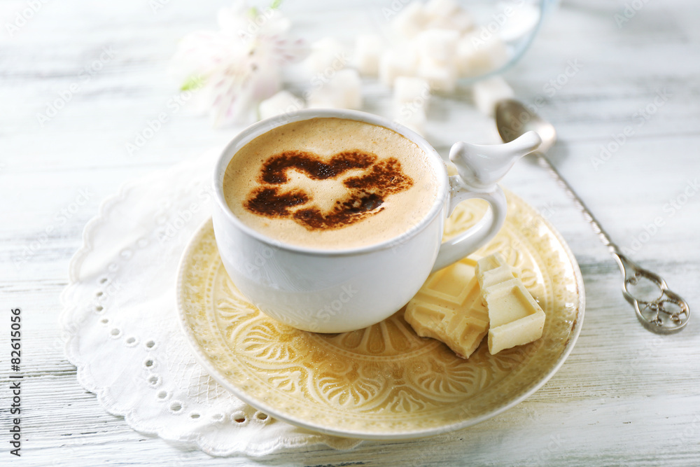 Cup of latte coffee art on wooden table, on light background