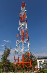 Telecommunication tower with antennas against blue sky 