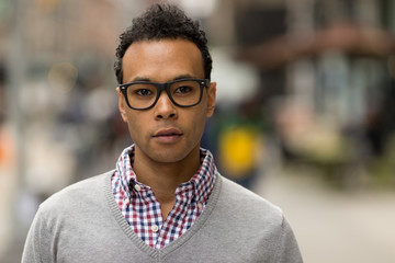 Poster - Young African Asian man in New York City serious face portrait