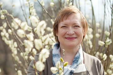 Wall Mural - Smiling senior woman  in spring willow