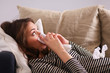 © shefkate - Portrait of a sick woman blowing her nose while sitting on the