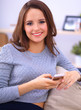 © shefkate - Pretty girl using her smartphone on  couch at home in the living
