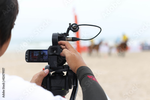Fotografie, Obraz Cameraman working on recording on a beach Polo Tournament
