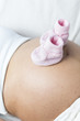 Schwangere Frau Detail Bauch mit Babyschuhen