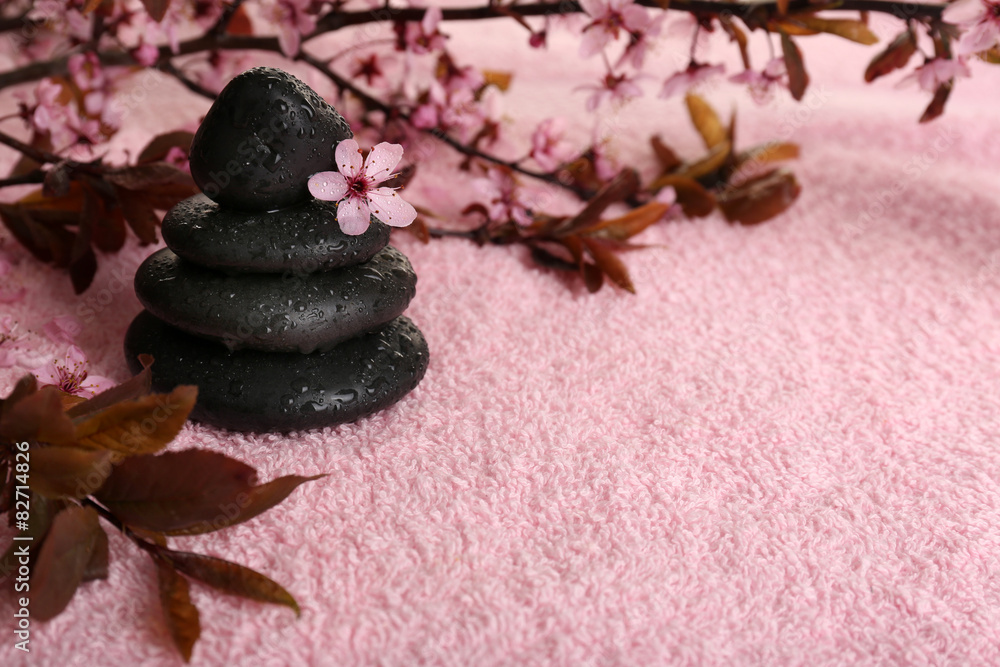 Spa stones and spring flowers on towel background