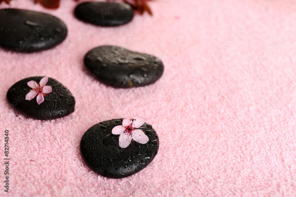 Spa stones and spring flowers on towel background
