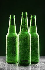 Poster - Glass bottles of beer on dark background