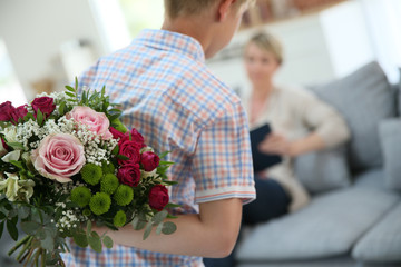 Wall Mural - Son hiding bouquet to surprise mommy on mother's day