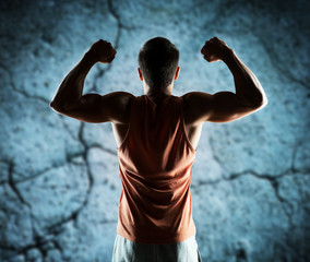 Wall Mural - young man or bodybuilder showing biceps