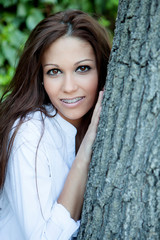 Wall Mural - Pretty brunette girl next to a tree