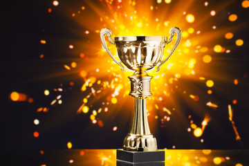 Wall Mural - gold cup trophy against shiny sparks background