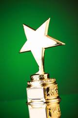 Wall Mural - gold star trophy against green background