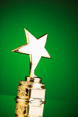 Wall Mural - gold star trophy against green background
