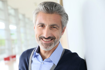 Portrait of smiling mature man standing in corridor