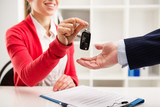Fototapeta  - Female car agent giving key to male customer for test drive. 
