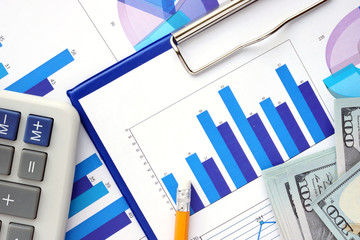 Papers with graphs, calculator and dollars. Finance concept. 