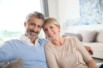 Wall Mural - Middle-aged couple relaxing in sofa at home