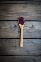 Wall Mural - Red powder (Aronia) in spoon on old wooden table