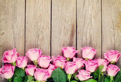 Fototapeta na wymiar Pink roses bouquet over wooden table