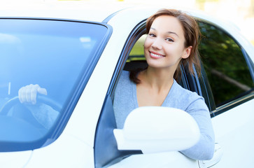 Wall Mural - Pretty girl in a car smiling to you