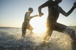 © Erik Isakson/Blend Images - Multi-ethnic swimmers running in surf