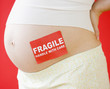© JGI/Jamie Grill/Blend Images - Pregnant Asian woman with fragile sticker on stomach