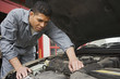 © JGI/Blend Images - Hispanic male auto mechanic under hood of car