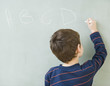 © JGI/Blend Images - Hispanic boy writing on blackboard