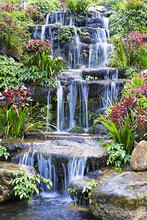 Artificial Waterfall And Statue At The Garden
