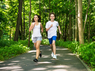 Wall Mural - Teenage girl and boy running in park