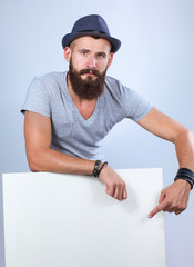 Portrait of young man standing in hat near blank