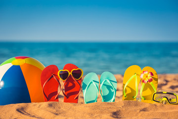 Flip-flops, beach ball and snorkel on the sand