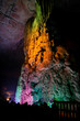 Colorfully lit stone formations in cave at guilin