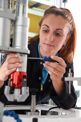 Wall Mural - Apprentice Female Engineer Working On Machine In Factory