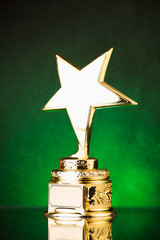 Wall Mural - gold star trophy against green particles background