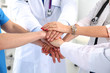 © lenetsnikolai - Doctors and nurses in a medical team stacking hands