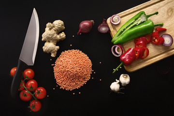 Knife and ingredients on dark background. Vegetarian food, healt