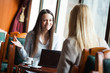 © djoronimo - Two young women sitting in cafe and talking