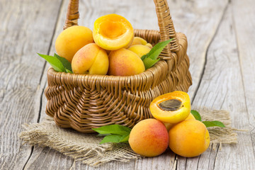 Sticker - fresh apricots in a basket on wooden background