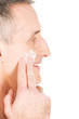 © Piotr Marcinski - Man applying cream on his face