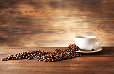 Poster - Cup of coffee with grains on wooden background