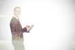 © WavebreakMediaMicro - Composite image of happy businessman using his tablet pc