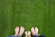 © Artsem Martysiuk - Family legs standing together on green grass