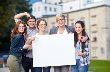 Wall Mural - happy teenage students holding white blank board